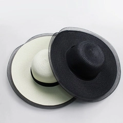 Detail of straw hats set in cream and black featuring elegant organza ruffled edges