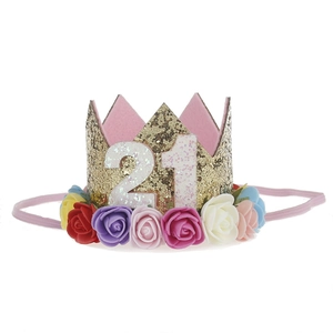 Detail of gold sequin birthday crown with number 21 and colorful artificial flowers