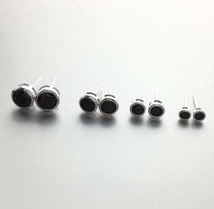 Macro detail of four pairs of 925 silver stud earrings with black round zircon in varied sizes