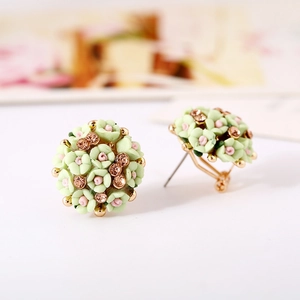 Macro shot of pastel pink and green flower stud earrings with crystal center detail