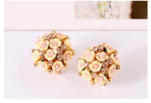 Close-up of floral earrings featuring soft yellow and pink petals with diamond accents