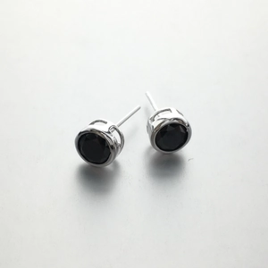 Macro detail of 925 sterling silver stud earrings with black round-cut zircon stones