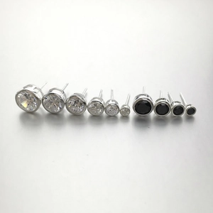 Macro detail of round bezel-set stud earrings in various sizes with black stones