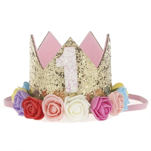 Close-up of golden glitter birthday crown with colorful roses and white number 1