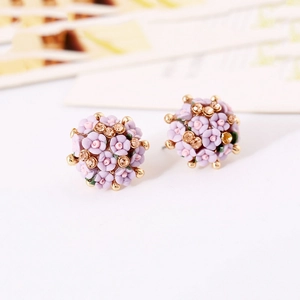 Close-up of lavender ceramic rose earrings with gold plating and sparkling rhinestones