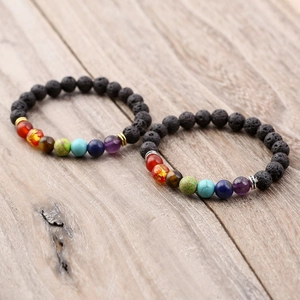 Lava stone chakra energy bracelet set with 8mm matte beads on a light wood background