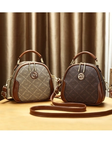 Detailed macro view of monogram shells handbags with gold hardware and logo on wooden stand