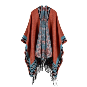 Reversible geometric tribal pattern poncho shawl with tassels in orange and teal colors