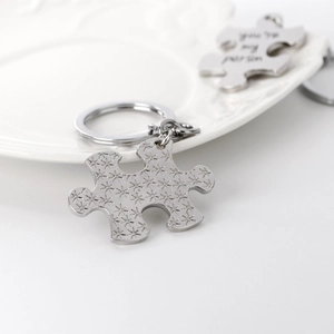 Detailed close-up of a silver puzzle keychain engraved with you're my person on white tray
