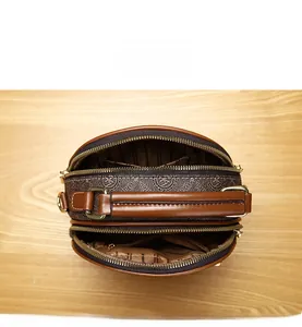 Detailed view of internal multi-layer storage with double zippers in a brown mini square bag