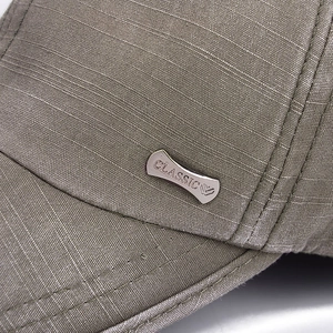 Side view of washed cotton baseball cap with a metal 'CLASSIC' emblem and grid texture