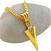 Detailed view of a gold arrow pendant necklace resting on a natural grey pebble stone