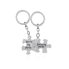Detail of silver interlocking puzzle piece keychains engraved with You're My Person
