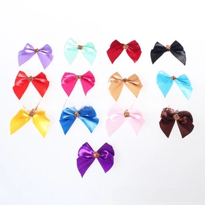 Detailed view of thirteen colorful satin bow accessories with center gemstone embellishments