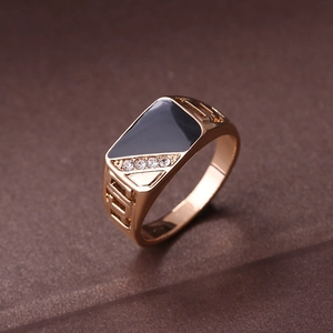 Detailed macro view of rose gold ring with black enamel triangle and white rhinestones
