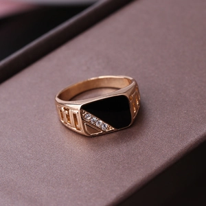Close-up of gold triangle ring with black enamel and greek key pattern on band