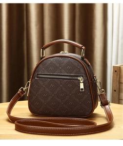 Close-up of brown monogram mini crossbody bag with gold hardware and leather texture