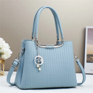 Elegant light blue embossed leather handbag with moon and star charms for women