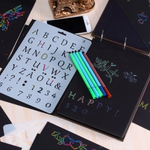 DIY black scrapbook set featuring plastic alphabet stencils and colorful neon pens on paper