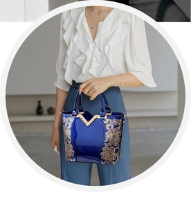 Détail du sac à main en cuir verni bleu roi avec broderie florale dorée et garniture en V