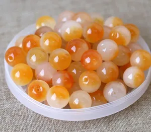 Macro shot of semi-transparent orange natural jade beads for DIY jewelry making and crafts