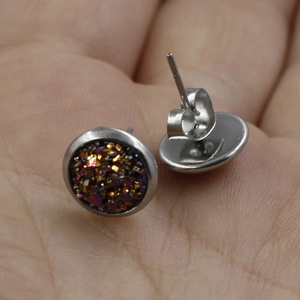 Macro shot of 8mm stainless steel stud earrings with glitter finish on a palm