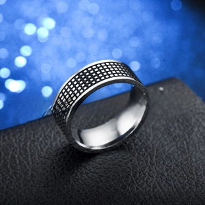 Macro shot of silver titanium steel ring featuring black and white checkerboard pattern