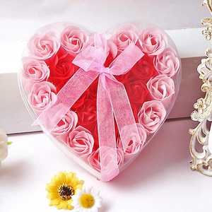 Pink and red soap flower roses in heart-shaped gift box with a delicate ribbon bow