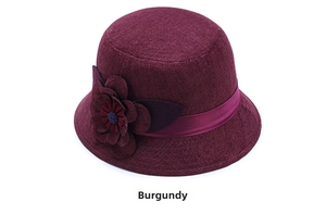 Detail of wine red linen sun hat featuring an elegant large flower decorative accent