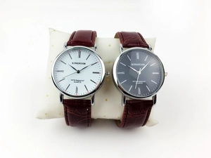 Detail of luxury couple watches with roman numerals and alligator leather straps
