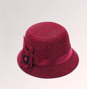 Detailed view of the handcrafted fabric flower and textured weave on wine red sun hat