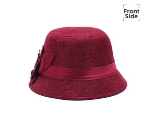Detailed view of a red linen sun hat featuring a large triple-layer floral ornament