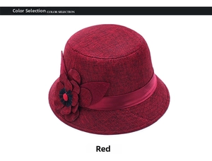 Detail of burgundy linen sun hat featuring a large 3D flower and satin ribbon