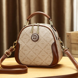 Summer mini crossbody bag with brown monogram pattern and golden hardware on wooden surface