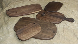 Detail of stacked black walnut cutting boards with natural grain on textured cloth