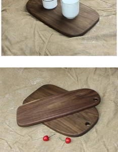 Detail of solid black walnut wood cutting board with handle and smooth grain finish