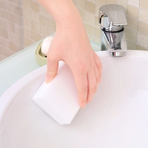 White nano magic cleaning sponge being used on a sink for effective stain removal
