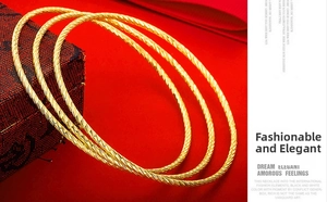 Detailed close-up of a three-piece set of gold-plated bracelets with spiral rope textures