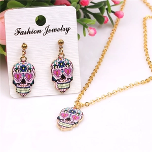 Detail of colorful sugar skull jewelry set with floral enamel work and golden finish