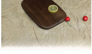 Macro shot of dark walnut wooden bread board grain texture and rounded corner finish