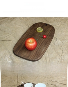 Detail of solid black walnut wood cutting board showing natural grain and hanging hole