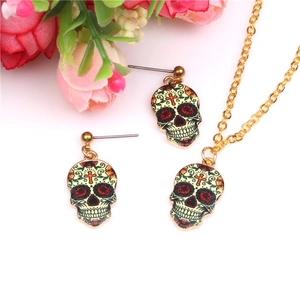 Detail of skull necklace and earring set with colorful patterns on a gold metal base