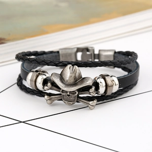 Close-up of woven leather bracelet featuring a vintage silver skull in a cowboy hat