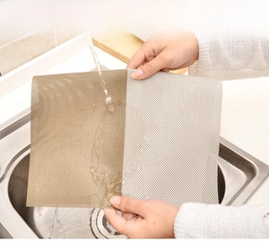 Washable woven PVC placemat being cleaned under running water to show stain resistance