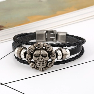 Macro shot of punk woven leather bracelet featuring a central vintage skull design