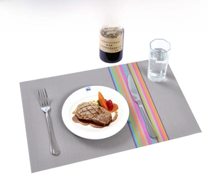 Detail of grey PVC woven placemat with colorful vertical stripes and textured surface