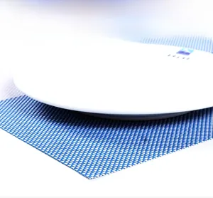 Close-up of blue and white woven PVC placemat featuring heat resistance and table protection