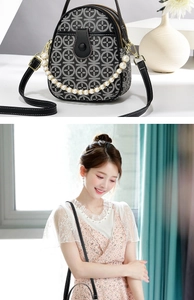 Detail of mini crossbody bag with pearl chain and dual zipper compartments