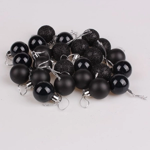 Close-up of black Christmas balls in shiny, matte, and glitter finishes with silver strings