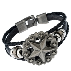 Detail of black braided leather bracelet featuring a vintage silver star and metal beads